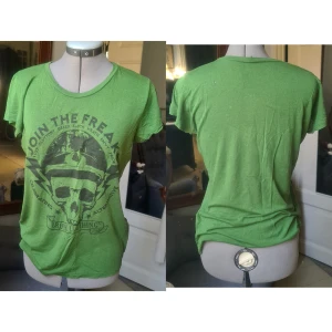 Grön t-shirt med tryck M - Okej skick, några hål, gammal. Tunn. 100% viskos från bomull.