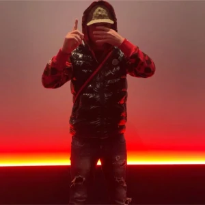 Svart glansig pufferväst - Säljer en svart glansig pufferväst med röda detaljer. Västen har en cool look med dragkedja och är perfekt för höst.