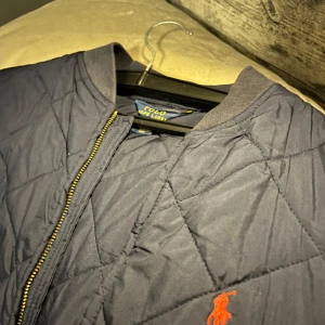 Navy blå quiltad jacka från Polo Ralph Lauren - Säljer en navyblå quiltad jacka från Polo Ralph Lauren. Ursprungligen storlek XL i barnstorlek men skulle säga att den passar XS/S i herr storlek också, säljer då den inte använts på många år! Väldigt bra skick då den inte används så mycket alls! Skriv gärna om du har funderingar!