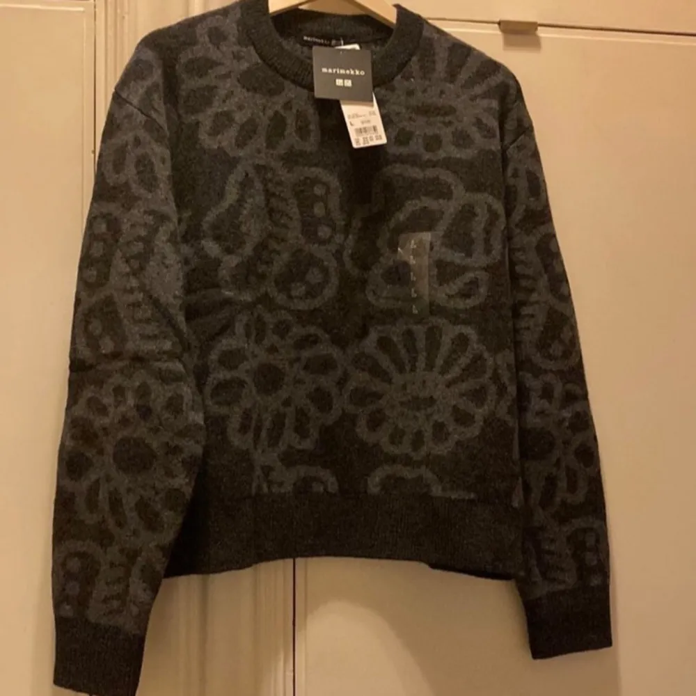 Säljer en snygg mörkgrå tröja från Marimekko x Uniqlo. Den har ett unikt blommönster och är perfekt för höst och vinter. Tröjan är långärmad och gjord i ett mjukt material som håller dig varm. Passar både till vardags och festliga tillfällen. 🖤. Tröjor & Koftor.