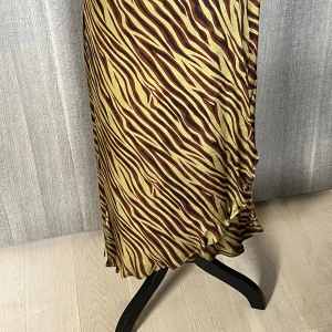 Zebramönstrad kjol - Säljer en supercool zebramönstrad kjol i brunt och grönt. Kjolen har en asymmetrisk volangdetalj längst ner som ger en extra touch av stil. Perfekt för både vardag och fest! 🦓✨