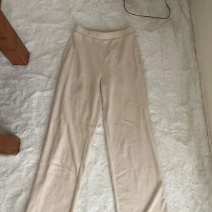 Beige byxor från Zara - Säljer ett par superbekväma beige byxor från Zara i storlek S. De är gjorda i ett mjukt material som känns skönt mot huden. Perfekta för en avslappnad dag hemma eller en casual utflykt. Byxorna har en enkel design utan mönster och en elastisk midja för extra komfort.