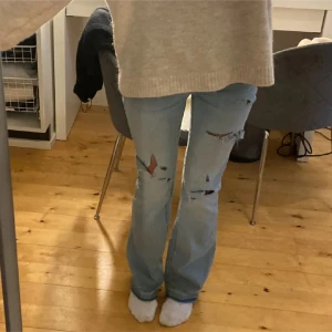 Bootcut jeans med revor - Jätte snygga ljusa bootcut jeans med hål. Jeansen är med midrise. Innebenslängd 84cm