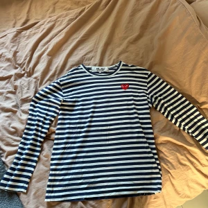 Randig långärmad tröja från Comme des Garçons - Säljer en superfin randig tröja från Comme des Garçons . Den är blå och vit med långa ärmar, perfekt för både vardag och lite finare tillfällen. Tröjan är i bra skick och väldigt bekväm.