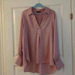 Beate blouse MQ - Beate blouse är en vävd långärmad blus från Stockh lm i en halvglansig och mjuk viskoskvalitet. Blusen har en avslappnad och rymlig passform. V-ringad halsringning med krage. Breda manschetter med 2 knappar. Nypris 699kr. 