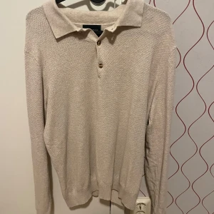 Beige stickad pikétröja från Grand Frank - Säljer en stilren beige stickad pikétröja från Grand Frank. Tröjan har långa ärmar och knappar framtill. Perfekt för både vardag och lite finare tillfällen. Passar bra till höst och vår. 🧥✨