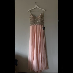 Balklänning - Aldrig använd (alla lappar finns kvar). Då min bal blev inställd fick jag aldrig chansen att använda den här fina klänningen. Den har ett litet släp baktill. För mig går klänningen ändå ner till marken. Nypris 1500kr.
