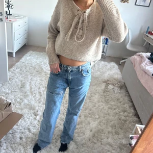 Blåa lågmidjade jeans  - Blåa lite större lågmidjade jeans med slitage på benet