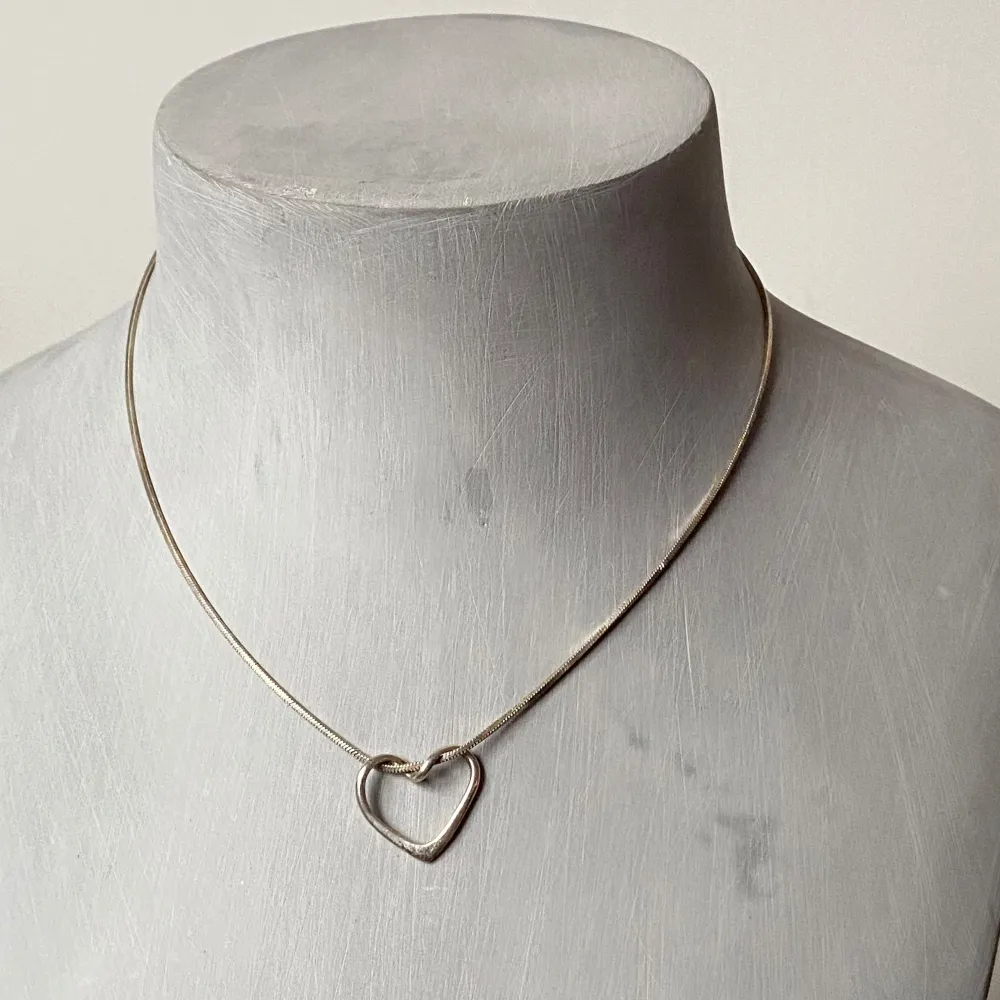 Säljer ett stilrent och elegant halsband i silver med ett öppet hjärthänge. Perfekt för både vardag och festliga tillfällen. Halsbandet har en smidig låsning baktill och en minimalistisk design som passar alla stilar. Ett måste för smyckesälskare! 💖stämplat 925. Accessoarer.