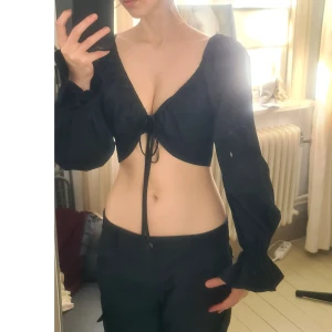 Puff sleeve topp med snörning 36 - Nyskick. 100% bomull. Passar nog 38-40 bättre, lös bak för mig. Blir bell sleeve och häxigt/70-tal om man repar upp ryschet vid handleden. Midjevidd 38, Ärmlängd 67