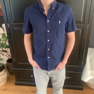 Ralph lauren skjorta  - Hej! Säljer nu en raffe skjorta med korta armar. Den är i mycket bra skick änvänd fåtal gånger Modelen på bilden är 178cm och väger 65 kg.Hör av dig vid eventuella frågor🌟