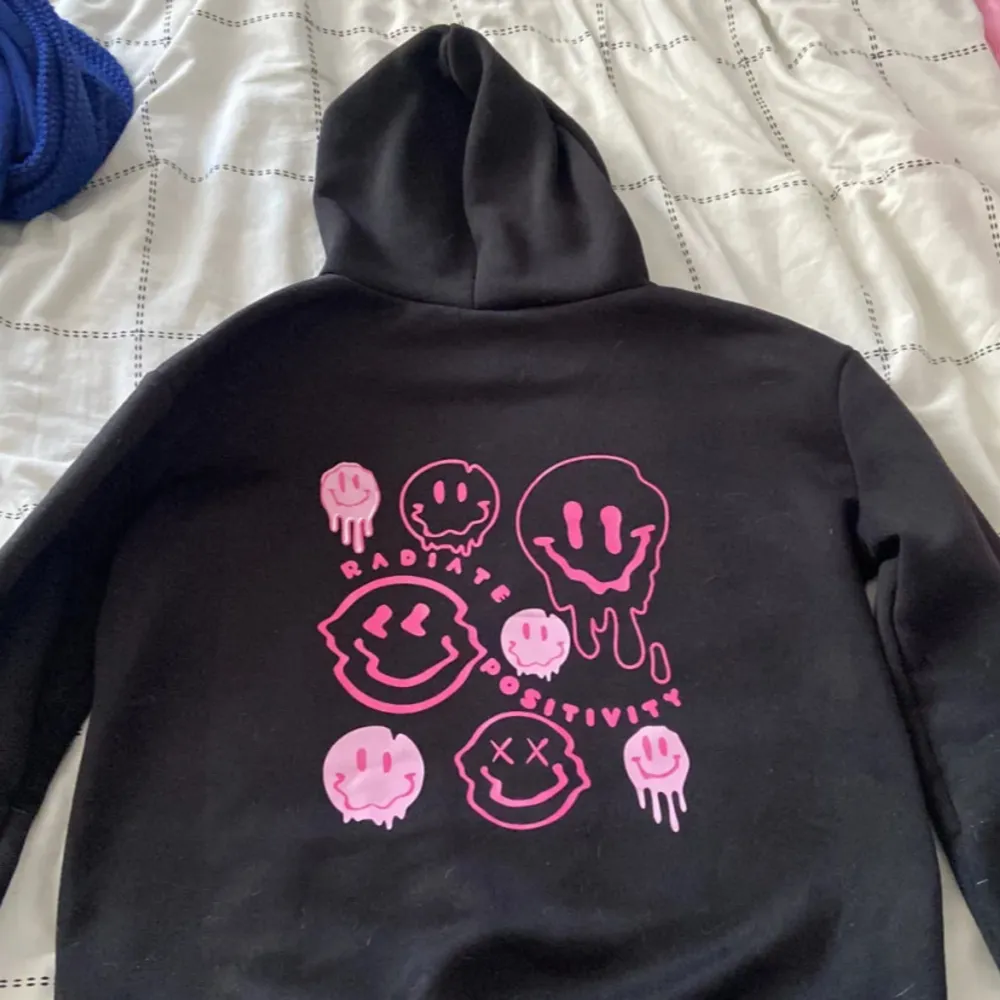 Säljer en svart hoodie med coolt rosa tryck på baksidan. Den har en känguruficka och justerbar huva. Perfekt för höst och vinter, och den är superbekväm att ha på sig. Passar både till vardags och chillkvällar. 🖤💖. Tröjor & Koftor.