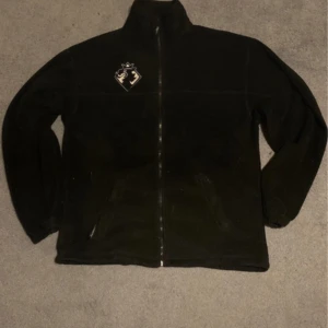 Svart Baggy Fliströja - Större baggy fliströja med väldigt mysig fit. Det finns ett justerbart band längst ner för att göra den tightare/lösare.  Köpt second hand men har inte använt så mycket. Inga tydliga tecken så slitage men lite använd bara.  Köp direkt/lägg förslag. 