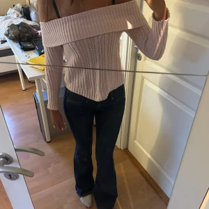 Ljusrosa stickad offshoulder-tröja - Säljer en superfin ljusrosa stickad tröja med offshoulder-design. Den är perfekt för både höst och vår, och har långa ärmar som håller dig varm. Tröjan är i nyskick och har en ribbad kant vid ärmslut och nederkant. Passar perfekt till ett par jeans för en avslappnad men stilren look!