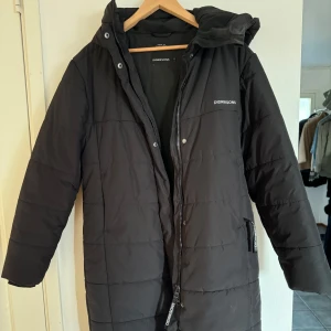 Vinterkappa - Jag säljer en längre svart vinterjacka i sportig model, den är varm och perfekt inför vintern.  Jackan är i bra skick, nästan oanvänd!  Den är i storlek 38 men skulle säga att den är mer som en s