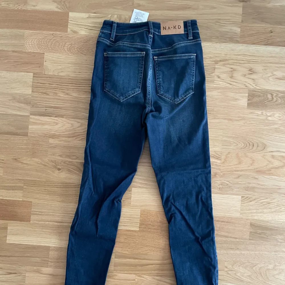 Blå jeans från NA-KD i storlek 34. Oanvända med prislappen kvar. Jeans & Byxor.