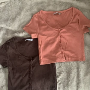 Toppar - En brun och en korall färgad tröjor. De är magtröjor och båda i storlek M. De är U ringade och har knappar hela vägen. Båda för 40kr!!💓