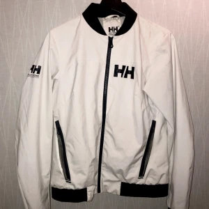 Helly Hansen Vindjacka - Bra skick! - Helly Hansen jacka unisex. En lätt och tunn vindjacka i storlek medium. Ganska liten i storleken. Skulle säga den passar 160cm-177cm.  Jackan är i använt skick.   Nypris 2000kr Mitt pris 795kr 