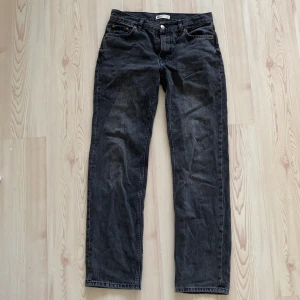 Svarta jeans från Perfect Jeans - Säljer ett par lågmidjade, svarta jeans från Gina tricot Jeans i storlek 36. De har en klassisk straight fit och är tillverkade i slitstarkt denim. Jeansen har en difekt på ena bakfickan. 