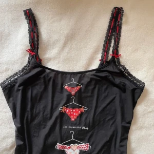 linne  - jättefint linne från intimissimi med detaljer i rött band, rosetter och spets med tryck. passar som nattlinne och vanlig topp <3 mycket gott skick!      cute, underwear, linne, topp, pyjamaq, underkläder, spets, romantisk, coquette, y2k, trend, fall,