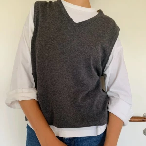 Grå stickad väst - Grå stickad väst (100% bomull) i mycket bra skick från Atlant. Västen är i storlek M (herr) så skulle säga L dam. Passar fint över t-shirts och skjortor!  Axelbredd: 42 cm Längd: 62 cm