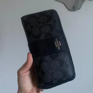 Coach plånbok  - Större Coach plånbok. Inköpt vintage i Tokyo så är inte helt säker att den är äkta men i väldigt bra skick. Knappt använd!