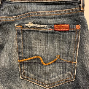 Jeans från USA märket 7 For All Mankind stl 26 - Coola jeans från USA, märket 7 For All Mankind, storlek w26, bra skick,  de slitningar som är på byxan är inte pga slitage. Rak modell