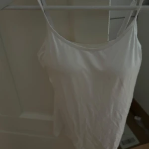 Vit Topp - En fin topp i mjukt material. Säljer då den inte kommit till användning. Pris kan diskuteras. 