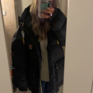 Svart fjällräven jacka - Fjällräven jacka i storlek S, är en gammal modell som är lite tjockare så känns som en storlek M nästan. Använd i två vintrar och är i bra skick, inga skador men har däremot tagit bort snöret som ska sitta längst ner💞