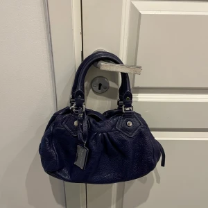 Mörkblå Marc Jacobs Väska - Mörkblå väska med silvriga detaljer. Jätte fint skick med knappt några tecken av användning. Skriv om ni har fler frågor 🥳❤️