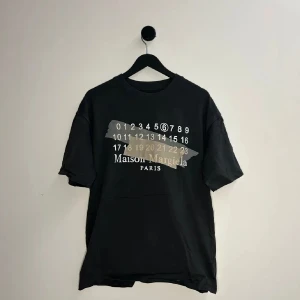 Maison Margiela T-shirt - En riktigt fet T-shirt från Maison Margiela, små tecken på användning men är i riktigt fint skick och perfekt för kommande säsonger🍁🍾! Storlek 44, vilket motsvarar ungefär S/M💫💯. Hör gärna av er vid flera frågor eller funderingar! 