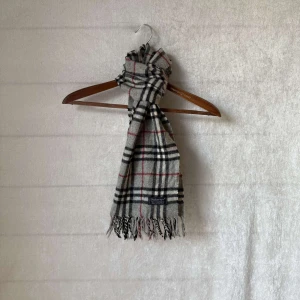 burberry halsduk  - Säljer en klassisk rutig halsduk frän Burberry i grå. Den gjord av 100% kashmir. Perfekt för att halla sig varm under höst och vinter. Superfin att ha både till vardags och fest! Skicket är 9/10 utan defekter och äkta såklart! 