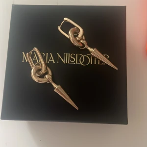 Örhängen nitar -  väldigt coola nit örhängen i guld. Jag tycker att dessa är väldigt lika Maria Nilsdotter örhängen. Örhänget är ca 5 cm lång och det är väger knappast någonting. Hör av er vid frågor! 🩷🩷