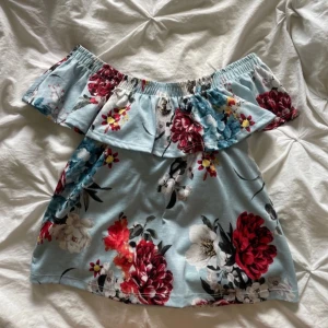 Off-shoulder topp - En blommig topp som är off-shoulder. 