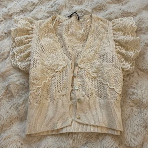 Beige spetsväst från Zara - Säljer en superfin beige spetsväst från Zara med puffiga ärmar och knappar framtill❤️❤️