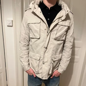 Hackett London fältjacka  - Beige fältjacka i strl M. Jackan är sparsamt använd men det tillkommer lite missfärgning på insida krage, dock inget som syns vid användning! Modell: 187 cm 80 kg