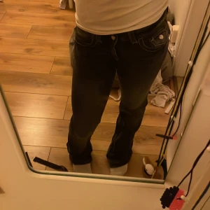 Svarta jeans med knappar - Snygga svarta jeans med en klassisk design och knappar framtill. Perfekta för en avslappnad stil. De har en utsvängd passform och är tillverkade i ett slitstarkt material.