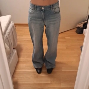 Blå bootcut jeans - Snygga blå bootcut jeans med låg midja och klassisk femficksdesign. Perfekta för en avslappnad stil. De har en knapp och dragkedja framtill.