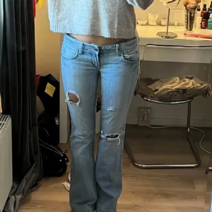 ljusblå bootcut jeans  - Snygga blå bootcut jeans med slitningar på låren och knäna. Köpta på plick för 900kr. innerbenlängd=81cm💕💕 det finns en fläck som visas på bild tre som var där när jag köpte dem, själv tycker jag det inte syns eller märks.De är även slitna längst ner.