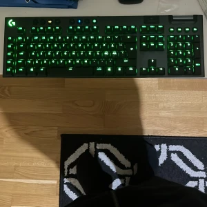Gamingtangentbord med grön belysning - Säljer ett Logitech gamingtangentbord med grön bakgrundsbelysning. Tangentbordet har en stilren design och är perfekt för gaming. Det medföljer en USB-mottagare för trådlös anslutning. Perfekt för den som vill ha en snygg och funktionell setup!