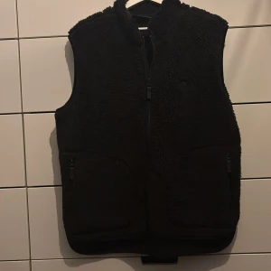 Svart fleeceväst med dragkedja Från J Lindberg - Säljer en svart fleeceväst med dragkedja framtill. Västen har en mysig och varm känsla, perfekt för kyligare dagar och våren västen är från JL och har därför sjukt bra kvalité och det är ett schysst pris 