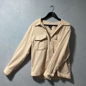 HM tröja Manchester Beige - Säljer en riktigt snygg Manchester mönstrad overshirt i beige färg från H&M, säljer pga att den inte kommer till användning så ofta. Tröjan är riktigt snygg och kan användas som overshirt/jacka närmare våren och sommaren och perfekt som bara vanlig tröja när kylan kommer. Overshirten är från H&M i storlek M och är i mycket gott skick. Skick 9,5/10 (kunde inte hitta några defekter) Storlek medium// priset kan diskuteras 