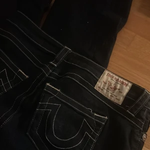 Mörkblå bootcut jeans från True Religion - Snygga mörkblå bootcut jeans från True Religion med vita sömmar:3 Modellen är BECCA mid rise bootcut W27, säljer då de var stora för mig. 