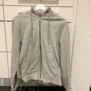 Moncler hoodie grå - Storlek M, 9/10 skick. Lite skrynklig eftersom den inte används på ett tag. Modellen heter Tricolor. Tag funkar. Nypris ca. 4800kr, mitt pris är 2000kr. Kan få fler bilder om önskas.