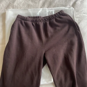 Bruna mjukisbyxor från Basically Basics - Säljer ett par bruna mjukisbyxor från Gina Tricot kollektion Basically Basics. Byxorna har en elastisk midja och är tillverkade i ett mjukt bomullsmaterial. Finns fickor. Perfekta för en avslappnad stil.