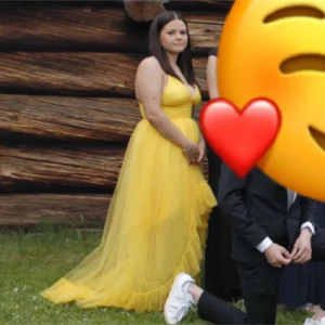 Gul långklänning med volangdetaljer - Snygg gul långklänning med volangdetaljer och v-ringad design. Klänningen har smala axelband och en asymmetrisk nederdel som ger en elegant look. Perfekt för sommarens festligheter!                     Balklänning säljes, använd endast en gång! Mycket fint skick, storlek 42 men liten i storleken passar mig som vanligtvis har 38. Nypris 1700kr, säljes för 900kr. Köparen står för frakten. DM för fler bilder på klänningen