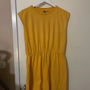 Gul klänning  - Säljer en solgul klänning från H&M Divided. Klänningen har en enkel design med elastisk midja och är ärmlös. Perfekt för varma dagar och kan enkelt stylas med accessoarer. 
