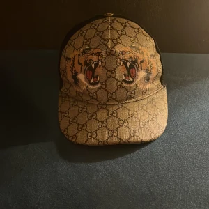 Gucci tigger keps  - Gucci tigger keps sällsynt modell säljs inte längre 8av10 skick storlek M fråga om du undrar något pris kan diskuteras kan byta mot annan Gucci keps! Ny pris ca 5000kr (valfri byxor tröja eller t shirt på köpet om man vill) 