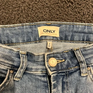 Blå jeans från ONLY - Snygga blå jeans från ONLY i storlek S. De har en klassisk femficksdesign och en knappgylf. Perfekta för en avslappnad stil.