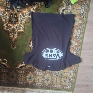 Svart t-shirt från Vans - Säljer en svart t-shirt från Vans med det klassiska 'Off The Wall'-trycket i vitt på framsidan. Perfekt för en avslappnad stil.